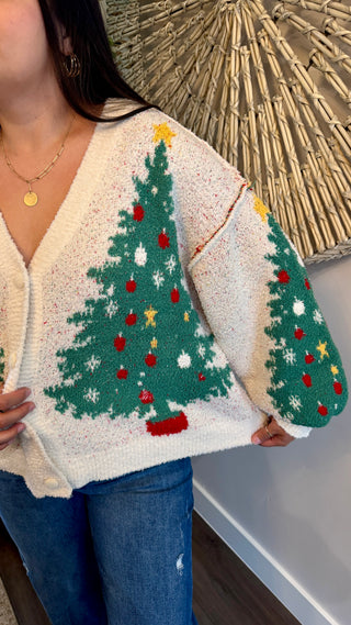 Person wearing a cardigan with Christmas tree pattern