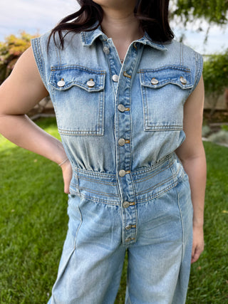 A woman wearing a denim jumpsuit with buttons.