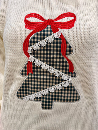 Christmas tree design with red bow and lace details on a white sweater.