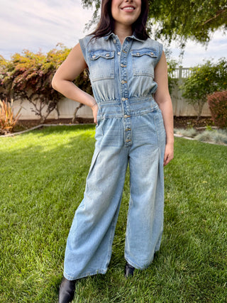 A woman wearing a denim jumpsuit with buttons.