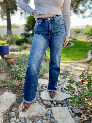 A woman wearing dark high waisted wide leg jeans with boots.