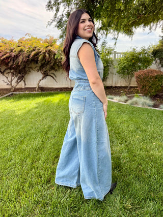 A woman wearing a denim jumpsuit with buttons.