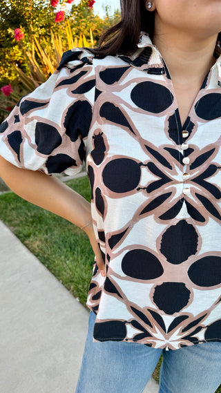 Close-up of the V-neckline on the Entro geometric print blouse.