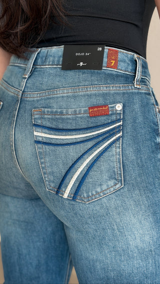 Detail of the 7 For All Mankind Dojo waistband label and red logo tab on women's long inseam flare jeans in Bluefern blue wash