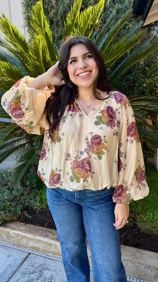 Woman wearing a floral long sleeve blouse and blue jeans 