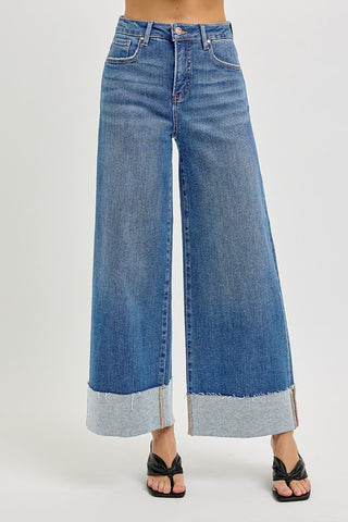 A pair of blue denim wide-leg jeans with a high waist and a big cuff.