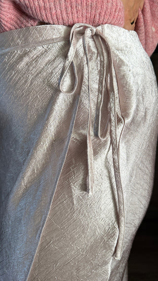 Woman wearing a pink sweater and Ivory satin skirt.