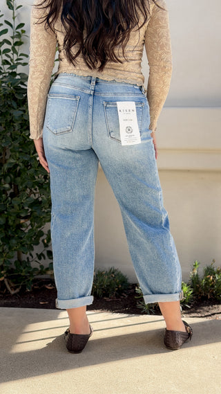 Back view of Risen high waisted barrel leg jeans in light wash denim with back pockets and cuffed hem