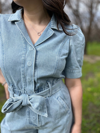 A woman wearing a denim short sleeve puff romper.