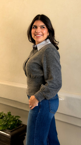 Side angle of a women's gray knit sweater top with white collar styled with jeans