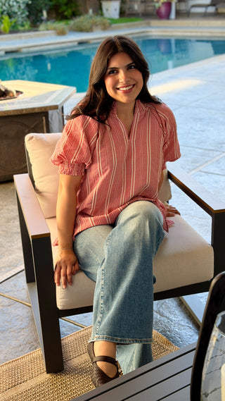Woman wearing a red striped blouse.