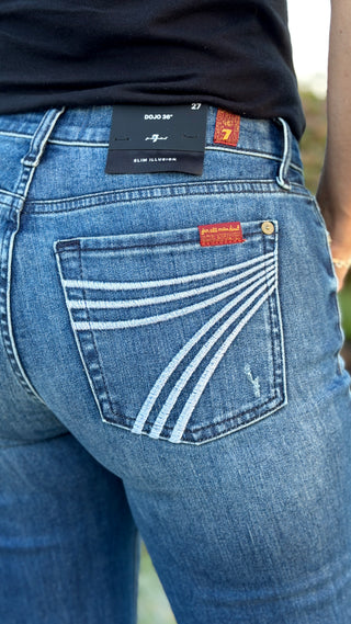 Person wearing blue jeans with a 7 stitched on pocket.