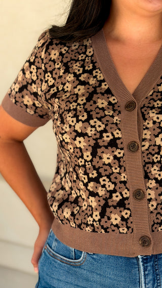 Close-up of the V-neckline, button front and floral knit pattern on a brown cardigan top