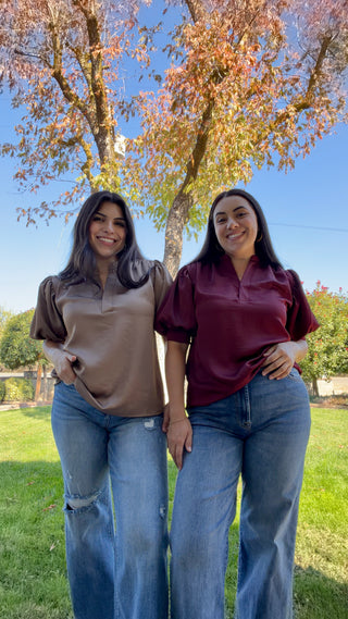 Women wearing a burgundy and brown V-neck blouse with ruffled sleeves.