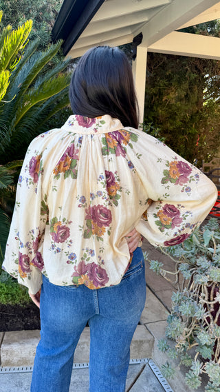 Woman wearing a floral long sleeve blouse and blue jeans 