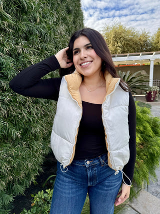 A woman wearing a reversible puffer vest with pockets. 