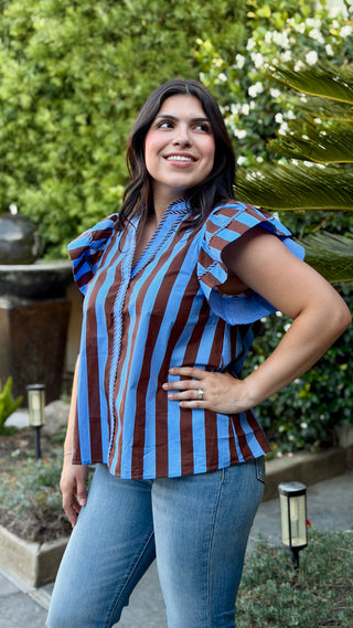 Side view of the Entro brown and blue striped V-neck blouse with ruffle sleeves.