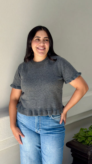 Front view of charcoal gray ruffle hem short sleeve sweater top with crew neck, worn with light wash high rise jeans