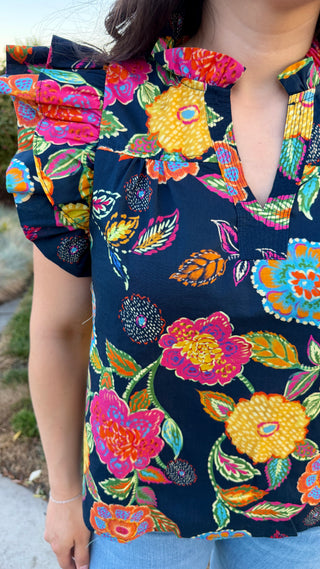 Colorful floral patterned top worn by a woman.