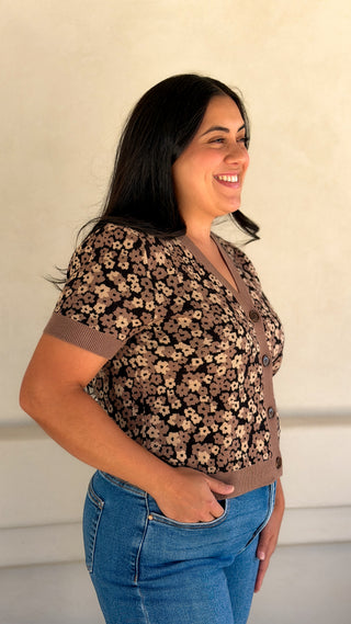 Side view of a women's brown floral short sleeve knit cardigan with jeans