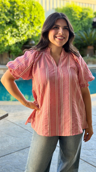 Woman wearing a red striped blouse.