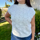 Woman wearing a light blue knitted top outdoors