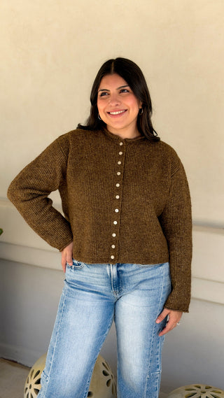 Front view of olive brown ribbed knit button front cardigan sweater with crew neck and long sleeves, worn buttoned with light wash jeans