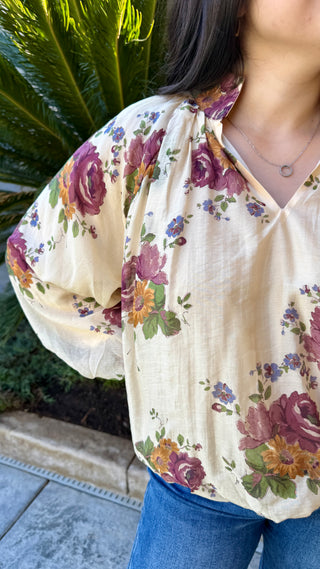 Woman wearing a floral long sleeve blouse and blue jeans 