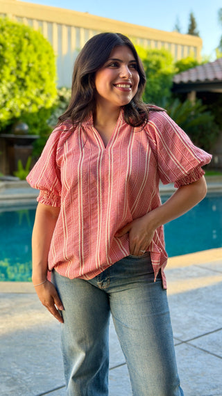 Woman wearing a red striped blouse.