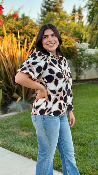 Side view of the Entro geometric print V-neck blouse with puff sleeves.