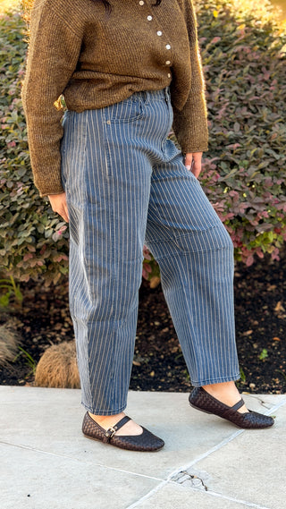 Model wearing pinstripe high rise barrel jeans with a brown cardigan, front view showing the curved leg and cropped length