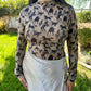 Person wearing a long-sleeve top with horse pattern outdoors
