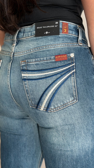 Detail of the 7 For All Mankind Dojo Tailorless waistband label and red logo tab on women's flare jeans in Bluefern blue wash