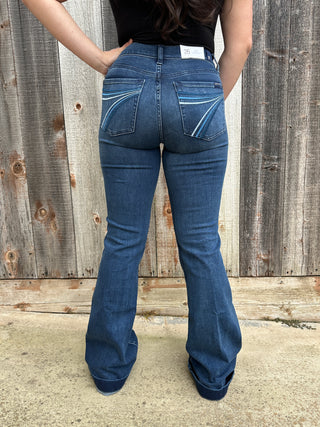  A woman wearing a rich dark wash, these jeans feature signature blue ombré ‘7’ stitching on the back pockets and are finished with the classic Dojo trouser hem.