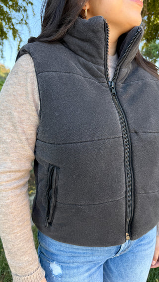 Person wearing a dark gray vest outdoors