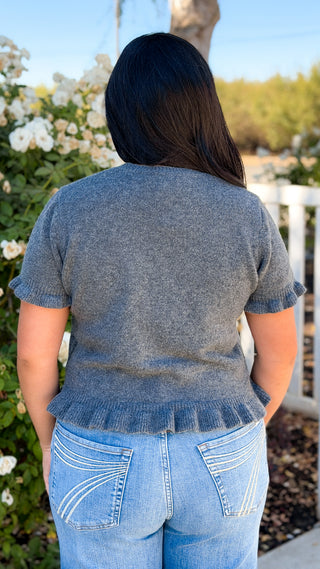 Back view of charcoal gray short sleeve sweater top with ruffle sleeves and ruffle hem