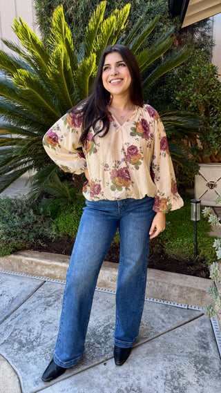 Woman wearing a floral long sleeve blouse and blue jeans 