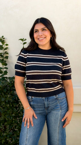 Navy and cream striped short sleeve knit top tucked into light wash jeans, front view
