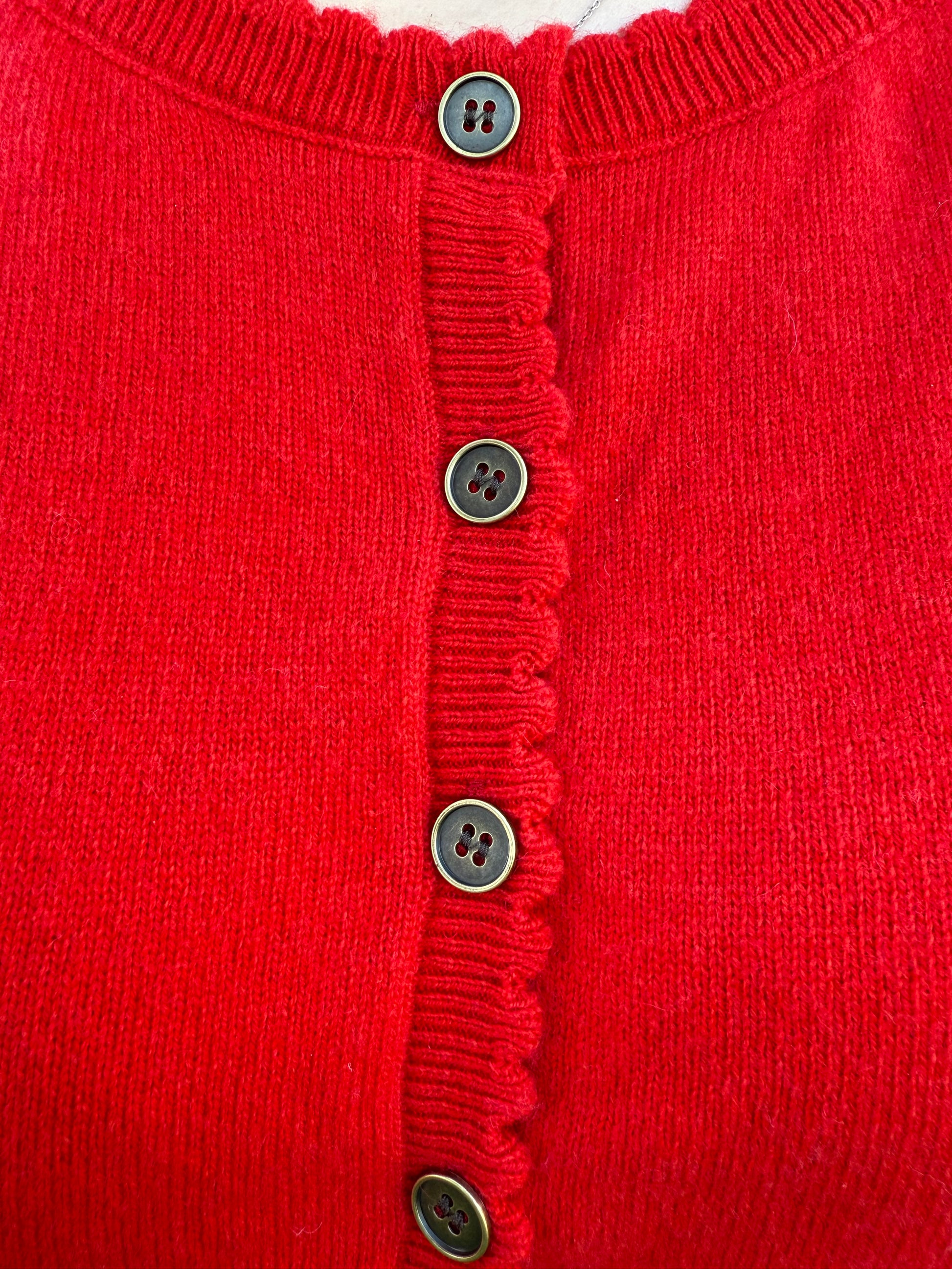 Close-up of a red garment with button details