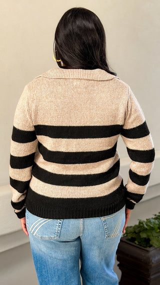 Back view of a women's black and cream striped V-neck sweater