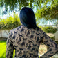 Person wearing a patterned shirt with animal designs outdoors