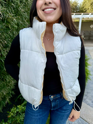 A woman wearing a reversible puffer vest with pockets. 