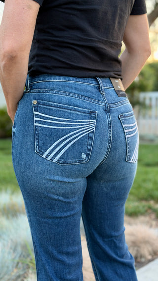 Person wearing blue jeans with a 7 stitched on pocket.