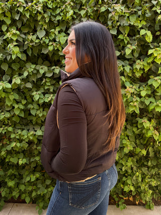 A woman wearing a reversible puffer vest with pockets. 