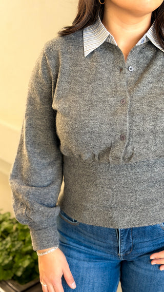 Close-up of the white contrast collar, bubble sleeve and fitted ribbed waist on a gray sweater top