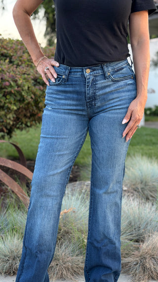 Person wearing blue jeans with a 7 stitched on pocket.