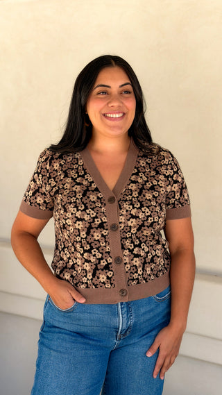 Woman wearing a brown floral knit short sleeve V-neck cardigan top with blue jeans