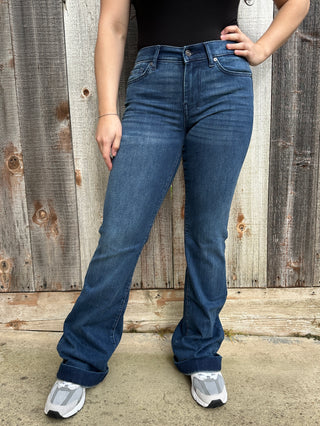  A woman wearing a rich dark wash, these jeans feature signature blue ombré ‘7’ stitching on the back pockets and are finished with the classic Dojo trouser hem.