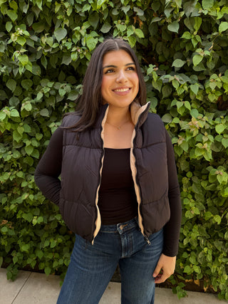 A woman wearing a reversible puffer vest with pockets. 
