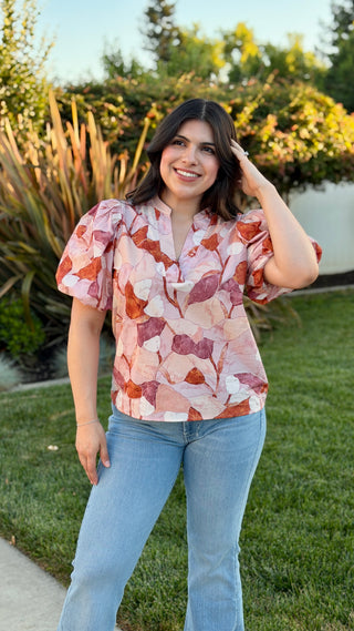 Woman wearing a floral blouse with blue jeans.